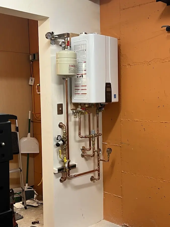 Plumbing technician inspecting water heater connections in Thousand Oaks